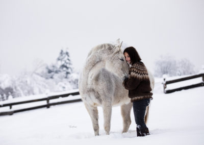 Fotografie Frau mit weissem Pferd in Schnee